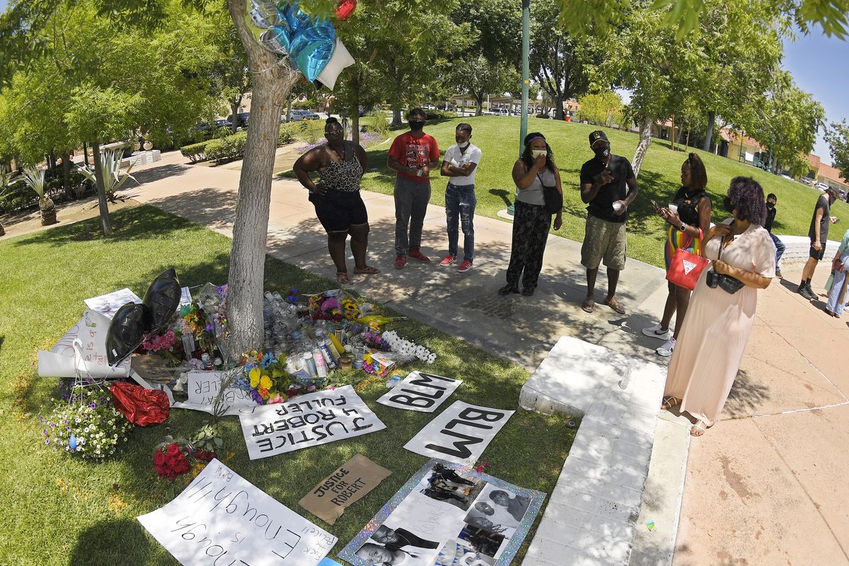 FILE - In this Monday, June 15, 2020, file photo, people stand by a memorial as they gather near the site where Robert Fuller was found hanged in Palmdale, Calif. A police investigation confirmed suicide was the cause of death of Fuller, a Black man found hanging from a tree in a Southern California city park last month, authorities said Thursday, July 9, 2020.  (Mark J. Terrill)