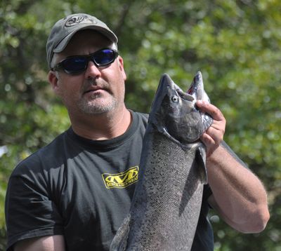An angler holds a chinook salmon caught while fishing on the Klickitat River. (Rich Landers)