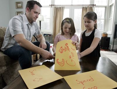 Kevin McLaughlin watches as 8-year-old daughter Chloe McLaughlin and her friend Caleigh Everitt, 9, right, count some of the allowance money Chloe keeps in different envelopes, at the McLaughlin home in Pine Beach, N.J. (Associated Press / The Spokesman-Review)