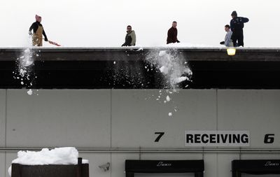 Victoria Hanko, Nick DiBartolo, Jason Clark, Rod Wieber and Rick Gallinger shovel off the roof of the Second Harvest Inland Northwest warehouse  on Monday.  (Jesse Tinsley / The Spokesman-Review)