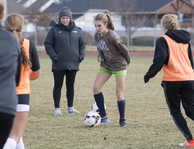 University girls soccer coach Megan Perkins, center left, watches over drills while standout midfielder Kelcey Crosby, center right, dribbles during a practice Wednesday at University High School. (Jesse Tinsley / The Spokesman-Review)