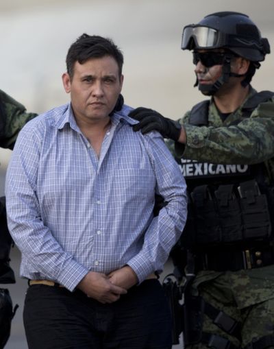 Omar Trevino Morales, left, is moved from a military plane to a military vehicle in Mexico City after his arrest Wednesday. (Associated Press)