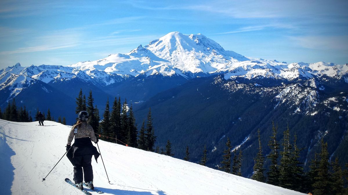 Skiers take in the view of Mount Rainier from a trail near the top of Crystal Mountain. (John  Nelson / The Spokesman-Review)