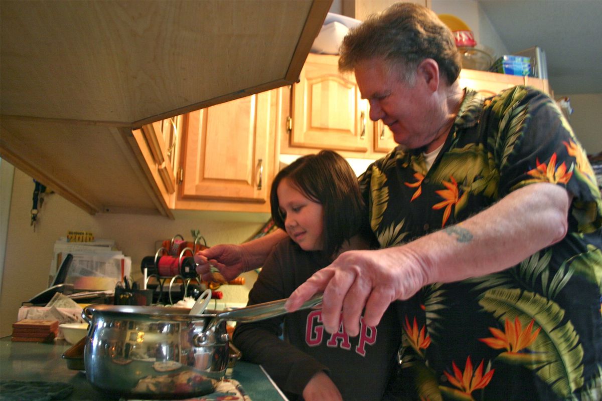 Dave McCullough teaches his granddaughter Chloee Lucki, 10, to make the orange rolls that are a Christmas morning tradition in his family.