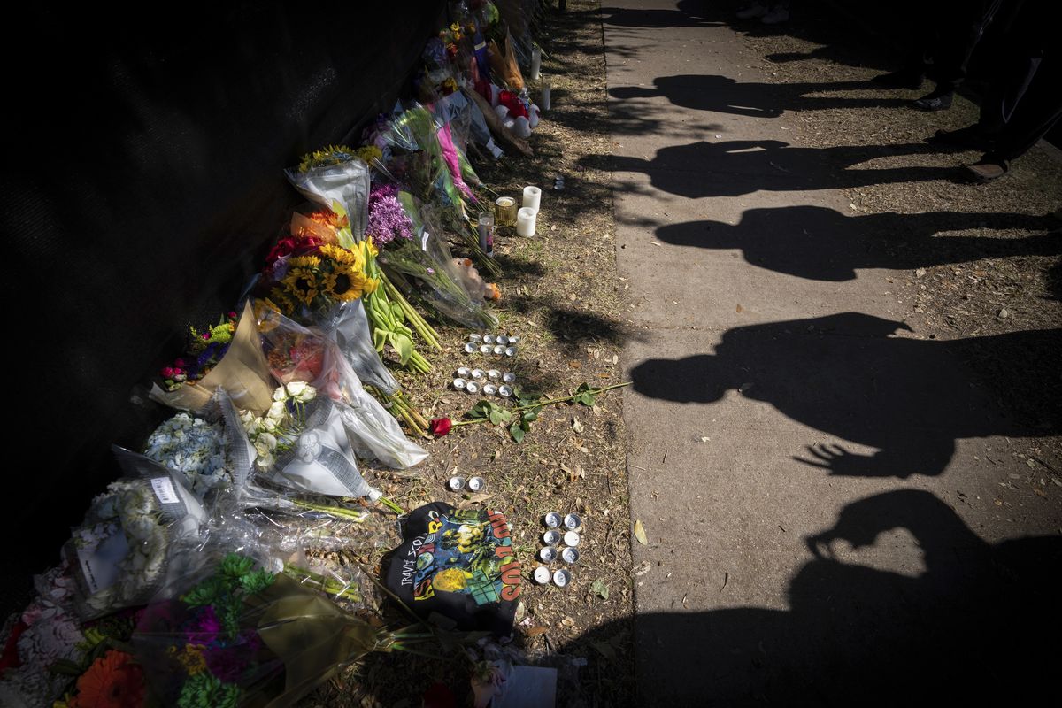FILE - Visitors cast shadows at a memorial to the victims of the Astroworld concert in Houston on Nov. 7, 2021. The 10 people who lost their lives in a massive crowd surge at the Astroworld music festival in Houston died from compression asphyxia, officials announced Thursday, Dec. 16, 2021. (Robert Bumsted)