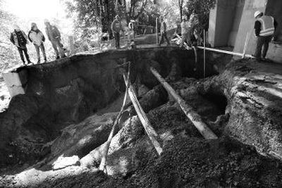 
Workers pump concrete  to fill a gap under the foundation of the University Bridge in Seattle on Thursday. A water main break on Wednesday created a sinkhole under the bridge that swallowed two cars and closed the bridge. 
 (Associated Press / The Spokesman-Review)