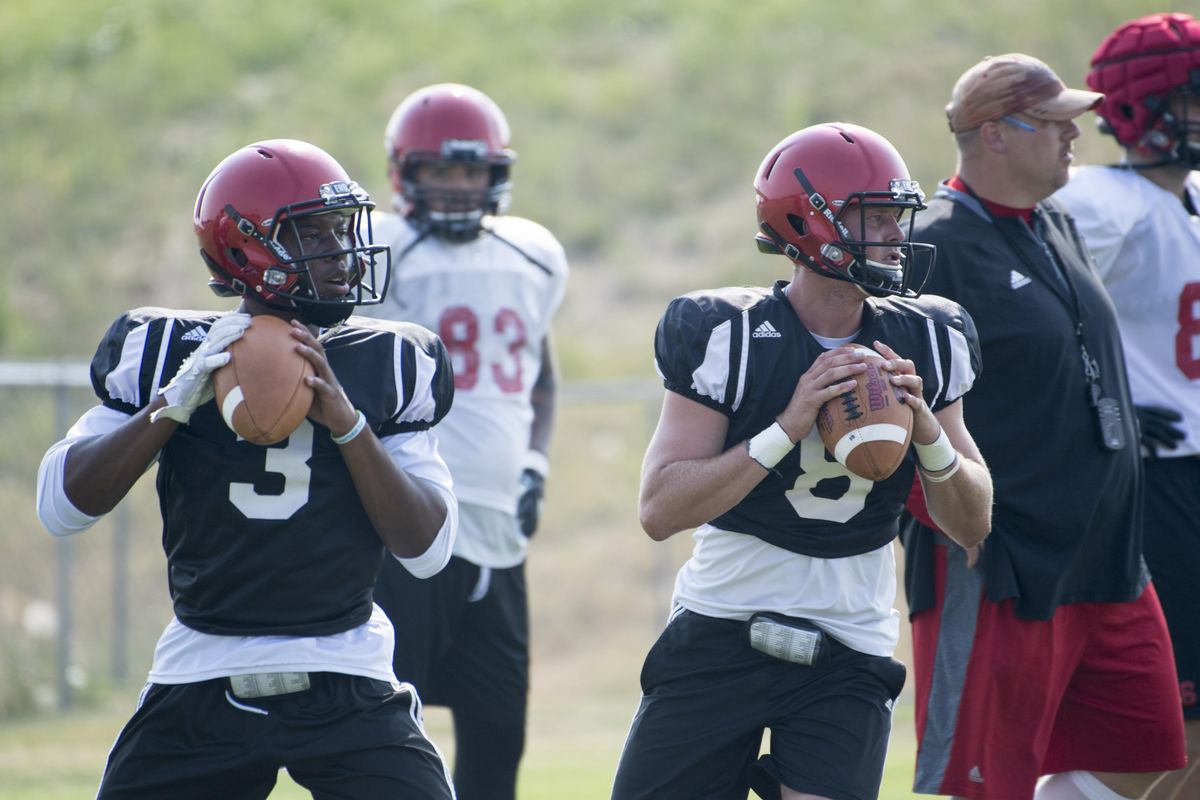 Starting quarterback Gage Gubrud, center (8), and his backup, Eric Barriere, left, work in tandem during drills. (Jesse Tinsley / The Spokesman-Review)