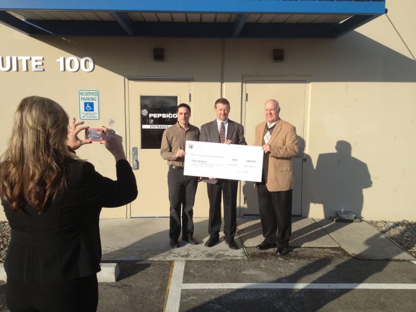 Photo of giant check presentation for $50,000 in state funds to Pepsico for moving to the Central Business Park in Spokane Valley. In photo, r to l, are Valley Mayor Tom Towey, Rick Cooper of Pepsi Bottling Co., and Dan Duer, general manager of Wolff Services. (Photo fro Wolff Services)