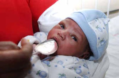 
A staff member at the Kenyatta National Hospital in Nairobi helps give water Thursday to baby Angel.
 (Associated Press / The Spokesman-Review)