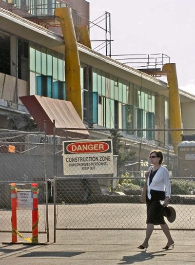 
Laila Miletic-Vejzovic walks past the Washington State University Compton Union Building remodeling project Aug. 4 in Pullman. Work on the CUB began earlier this summer and is expected to continue until fall 2008. 
 (Photos by Brian Immel / The Spokesman-Review)