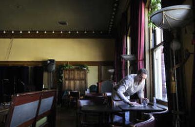 Joel Brooks cleans a table Tuesday at Ella's Supper Club in downtown Spokane. The 15,000-square-foot building that houses Ella's and  CenterStage requires sprinklers under a new state law, a fire official said – an expense that could lead to at least a temporary closure.  
 (Dan Pelle / The Spokesman-Review)