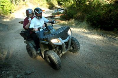 
Shawn Huckins, driving, and Beth Miller head up Canfield Mountain on their ATV Thursday afternoon, near Coeur d'Alene. 
 (Jesse Tinsley / The Spokesman-Review)
