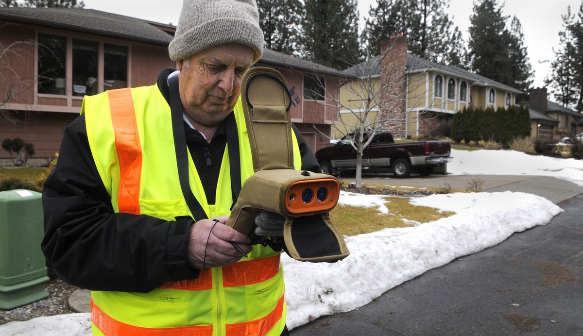 Mike Shannon, of the Spokane County 911 emergency system, uses a laser GPS unit to record the latitude and longitude of homes along College Place near Eaton Avenue in Spokane on Thursday. (Dan Pelle)