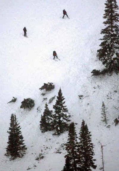 
Three search-and-rescue patrol members ski through debris at the scene of an avalanche in the backcountry adjacent to the Canyons Ski Resorts in Park City, Utah, Friday. 
 (Associated Press / The Spokesman-Review)
