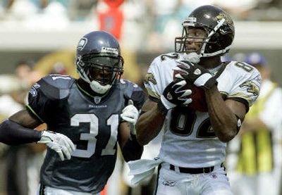 
Jaguars receiver Jimmy Smith, right, makes a third-quarter catch in front of Seahawks defender Kelly Herndon.
 (Associated Press / The Spokesman-Review)