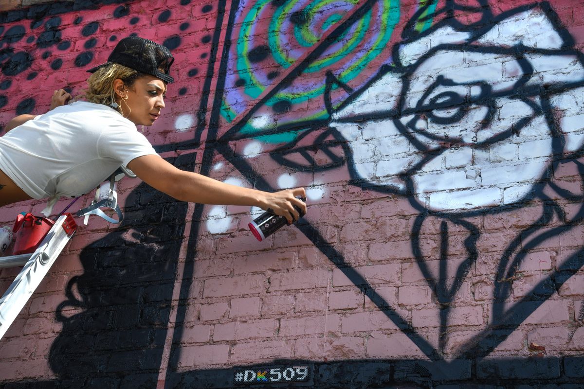 Street artist Amber Hoit applies her skills to the side of the Boots Bakery building during the Dker Graffiti Get Down, Saturday, Sept. 8, 2019, in downtown Spokane. (Dan Pelle / The Spokesman-Review)
