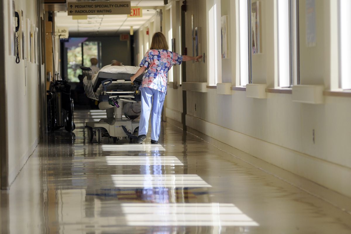 A staff member wheels a patient through the hallways of Providence Sacred Heart Medical Center on Wednesday in Spokane. (CHRISTOPHER ANDERSON / The Spokesman-Review)