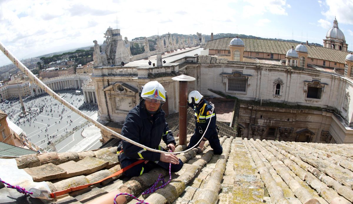 In this photo provided by the Vatican paper L’Osservatore Romano, taken on Saturday and made available Monday, firefighters install the top of the Sistine Chapel chimney that will signal to the world that a new pope has been elected. (Associated Press)