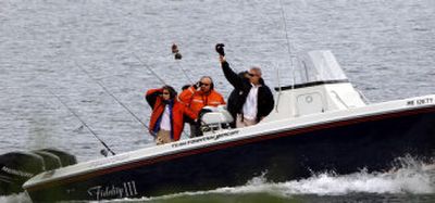 
President Bush waves his hat as he heads off to fish with his father, former President George H.W. Bush, partially seen behind him, in Kennebunkport, Maine, on Friday. 
 (Associated Press / The Spokesman-Review)