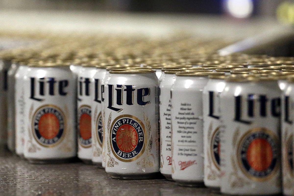 Newly filled and sealed cans of Miller Lite beer move along on a conveyor belt at the MillerCoors Brewery, in Golden, Colo. After turning down five offers, British-based brewer SABMiller, which sells beers including Miller Lite, Coors Light and Blue Moon in the U.S. and Puerto Rico through a joint venture with Molson Coors, accepted in principle an improved takeover bid worth 69 billion pounds ($106 billion) from Anheuser Busch InBev. Many analysts think that the merged company will be compelled to sell the Miller line of beers in the U.S. (Brennan Linsley / File Associated Press)