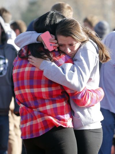 Students comfort each other outside of Arapahoe High School after a shooting on the campus in Centennial, Colo., on Friday. (Associated Press)