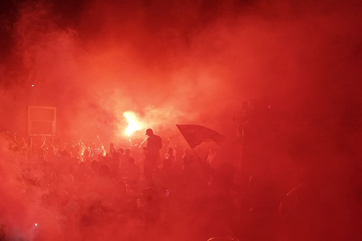 Liverpool supporters celebrate as they gather outside of Anfield Stadium in Liverpool, England, Thursday, June 25, 2020 after Liverpool clinched the English Premier League title. Liverpool took the title after Manchester City failed to beat Chelsea on Wednesday evening. (Jon Super)