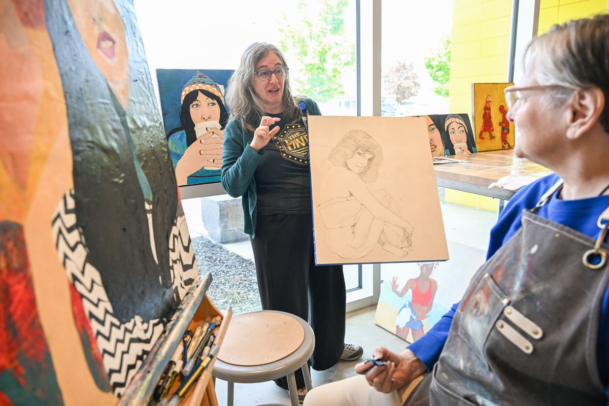 Eva Silverstone, left, talks with artist Sheri Medford, right, about her painting and drawing work that she is producing as an artist-in-residence at The Hive, a multipurpose center operated by the Spokane Public Library and Spokane Public Schools at 2904 East Sprague Avenue. Silverstone helped deisgn and run the artist-in-residence program since the opening of the The Hive building in 2021. Use of the art studios are awarded to artists who apply for the few slots available each year. (Jesse Tinsley/THE SPOKESMAN-REVI)
