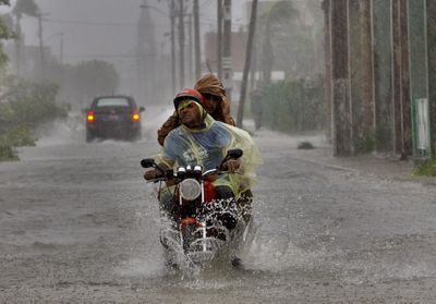 Residents make their way through a flooded street after Hurricane Ike hit Camaguey, Cuba.  (Associated Press / The Spokesman-Review)