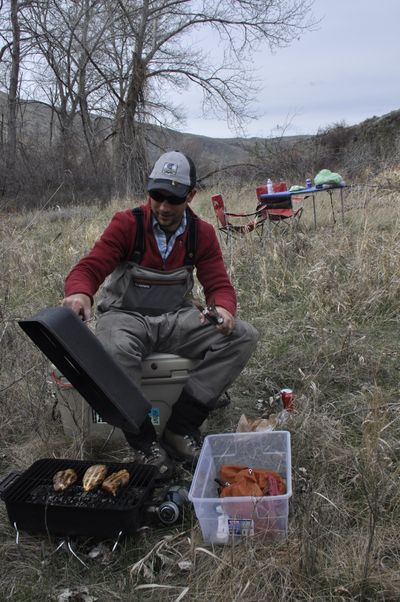 Yakima River fly fishing guide Stefan Woodruff barbecues chicken for lunch along the Yakima River. (Rich Landers)