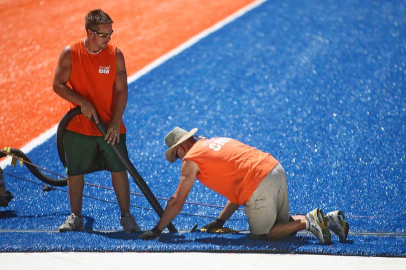 This photo taken Monday July 12, 2010 shows  FieldTurf crew members  Dan Moretti, left and Tim Stapchuck  from Pittsburgh, Pa working to install the new blue turf at Bronco Stadium. (Shawn Raecke / Idaho Statesman)