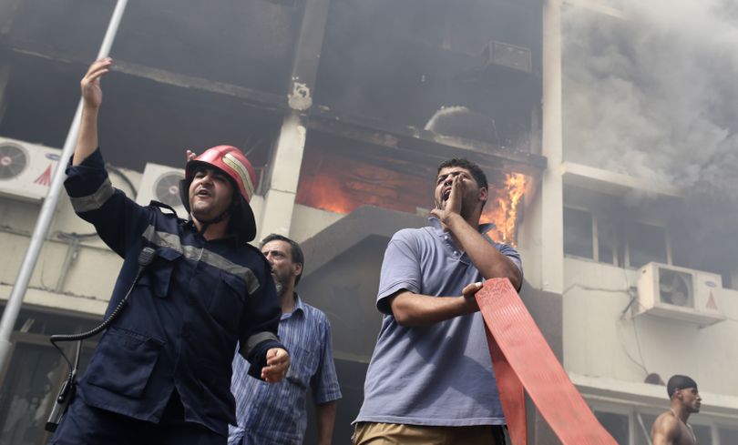 Egyptian firefighters battle flames at the Giza governorate buildings that were stormed and torched by angry supporters of Egypt's ousted president, Cairo, Egypt, Thursday, Aug. 15, 2013. Egypt faced a new phase of uncertainty on Thursday after the bloodiest day since its Arab Spring began, with hundreds of people reported killed and thousands injured as police smashed two protest camps of supporters of the deposed Islamist president. Wednesday's raids touched off day-long street violence that prompted the military-backed interim leaders to impose a state of emergency and curfew, and drew widespread condemnation from the Muslim world and the West, including the United States. (Hassan Ammar / Associated Press)