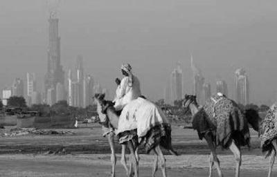 
A camel caravan passes with the Burj Dubai seen in the background in Dubai, United Arab Emirates. Oil services giant Halliburton Co. will soon shift its corporate headquarters from Houston to the Mideast financial powerhouse of Dubai.
 (Associated Press / The Spokesman-Review)