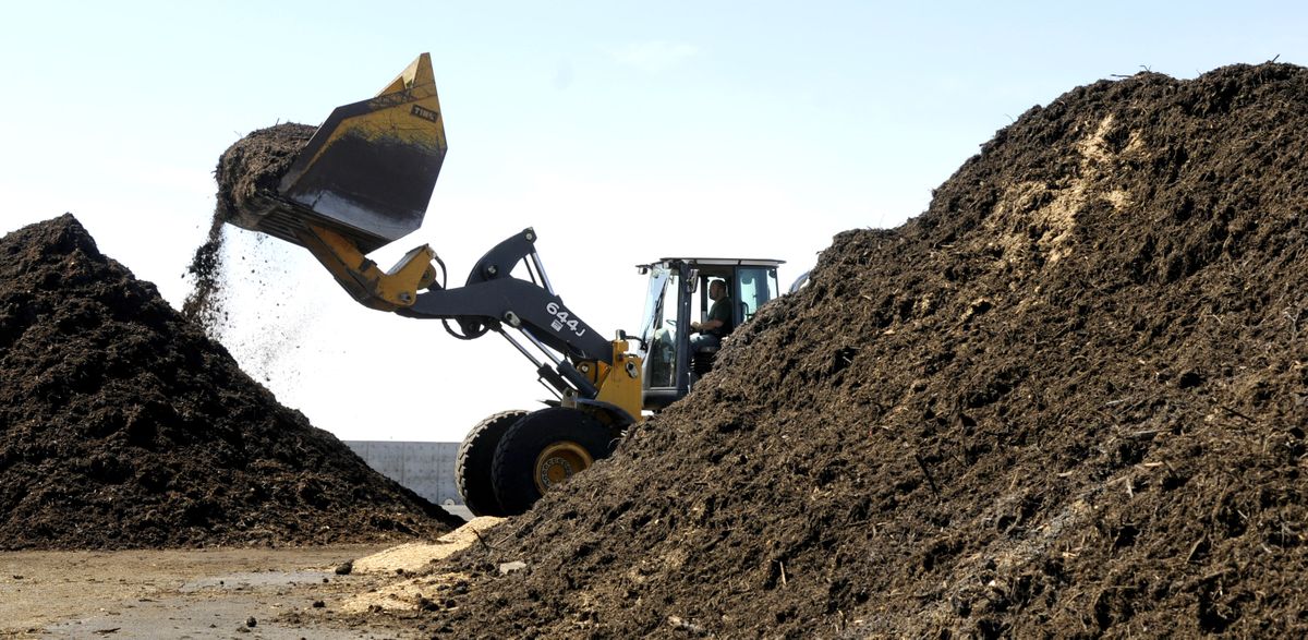 Larry Condon of Barr-Tech  turns and mixes a pile of compost at his facility near Fishtrap, Wash. At right is a pile of compost containing  rotting fish that died in recent weeks at Long Lake.  (Dan Pelle)