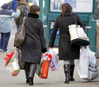 Two women head for the subway with their purchases after shopping in New York with one day remaining in the holiday shopping season last December.  (File Associated Press)