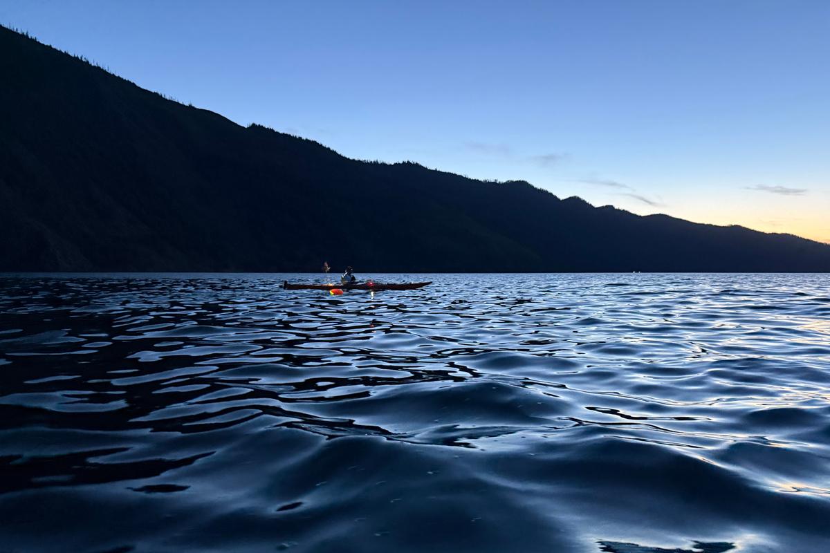Safety kayaker Brian Ellison paddles next to Ammi Midstokke during a late sunset on Lake Pend Oreille.  (Courtesy of Chad Fisher)