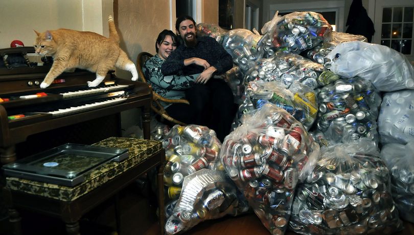 Andrea Parrish and Peter Geyer have collected about 4 percent of their 400,000-can goal. They plan to use recycling proceeds to fund their wedding. They have about 120 pounds of cans in the living room of their Spokane home, which they share with their cat, Smudgie. (Dan Pelle)