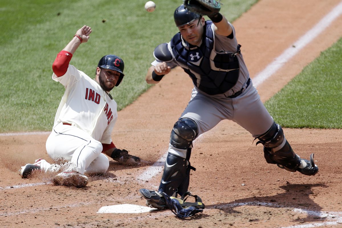 The Indians’ Mike Aviles scores from third as Mariners catcher Jesus Montero is late getting back to the plate in the fourth inning. (Associated Press)