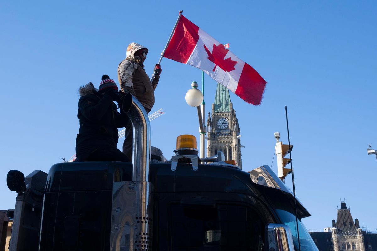 Protesters stand on the top of a truck parked in front of the Parliament buildings during a demonstration against COVID-19 restrictions, in Ottawa, Ontario, Saturday, Feb. 5, 2022.  (Adrian Wyld)