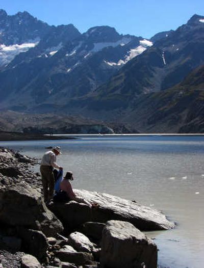 
Walkers take abreak at Hooker Lake in Mount Cook National Park, New Zealand.  New Zealand's highest mountain, Mount Cook, is visible fron locations on the west coast, but to get close to it also requires a detour from the easterside of the South Island.
 (Associated Press photo / The Spokesman-Review)