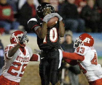 
Cincinnati receiver Derrick Stewart catches a 38-yard pass against two Rutgers defenders. 
 (Associated Press / The Spokesman-Review)