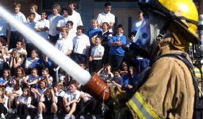 
Firefighter Jesse Ayotte demonstrates the use of a fire hose on Friday at St. Charles School. Firefighters from Station 13 demonstrated how they use the math and science the students are learning in their jobs every day.
 (Jed Conklin / The Spokesman-Review)
