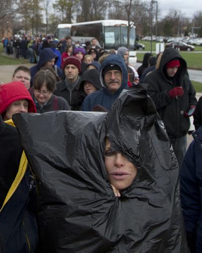 Justine Ovsenik of Willoughby Hills, Ohio, struggles to stay warm with the help of a trash bag as she waits in line to enter Mentor High School to hear President Barack Obama speak at a campaign event, Saturday, Nov. 3, 2012, in Mentor, Ohio, before he travels to Milwaukee for another Campaign event. (Carolyn Kaster / Associated Press)
