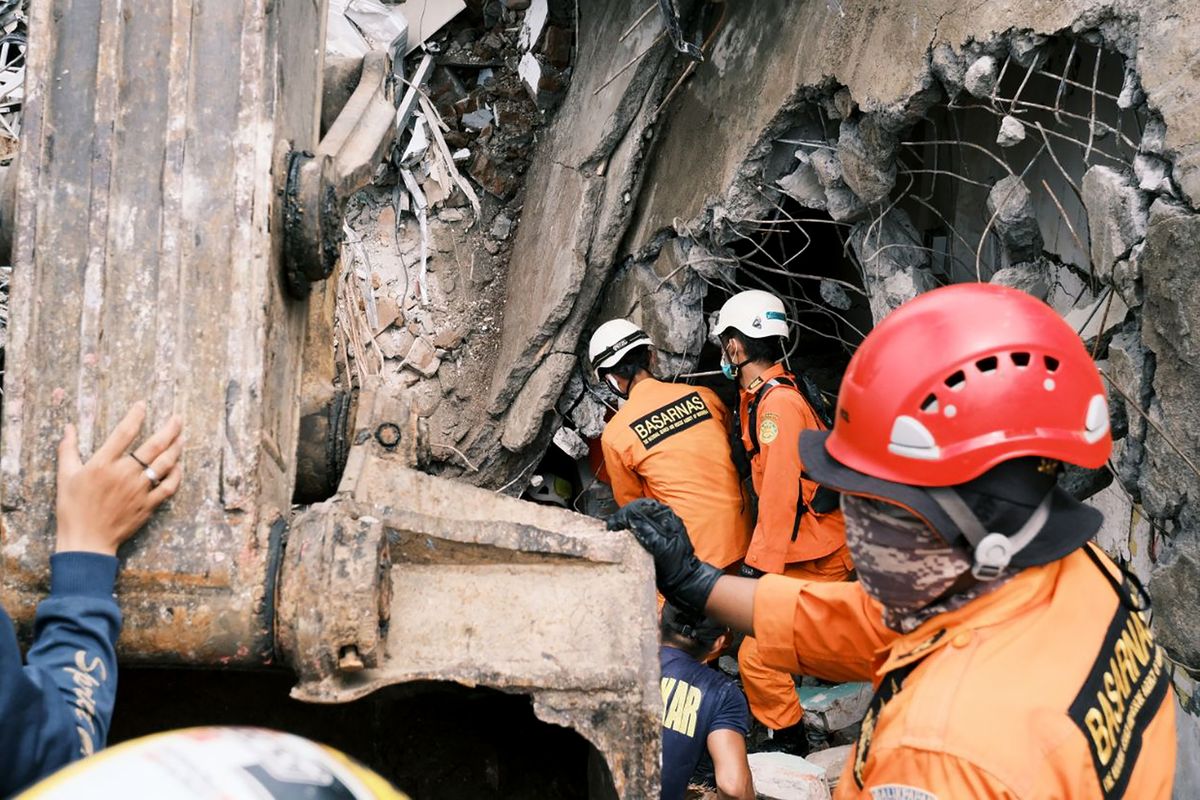 Rescuers search for victims Saturday at the ruin of a building damaged by an earthquake in Mamuju, West Sulawesi, Indonesia.  (Sadly Ashari Said)