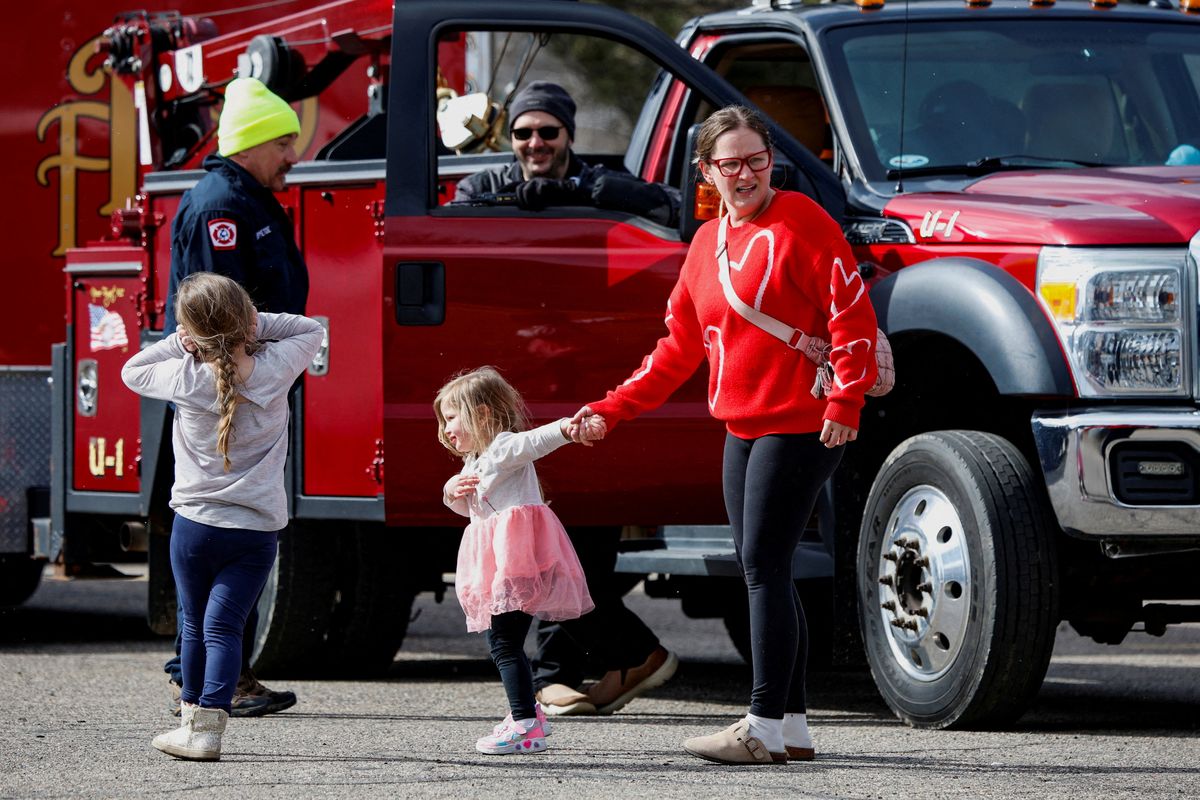 A mother who pulled her kids out of the Temple Israel Synagogue stands near emergency personnel after authorities reported an active shooting incident on Thursday in West Bloomfield, Mich.  (Reuters)