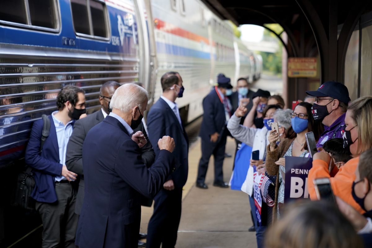 Democratic presidential candidate former Vice President Joe Biden greets supporters on the platform outside the Amtrak