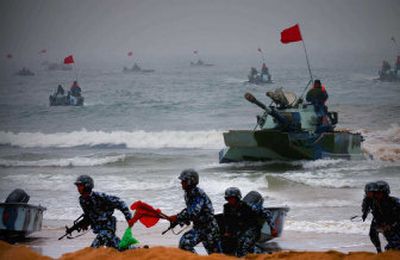 
Amphibious tanks and soldiers rush to the beachhead Wednesday in China's Shandong Peninsula. 
 (Associated Press / The Spokesman-Review)