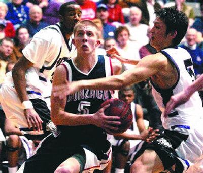 
Gonzaga's Derek Raivio cuts between Portland's Taishi Ito, right, and Sherrard Watson on his way to the basket Monday in Portland.
 (Associated Press / The Spokesman-Review)