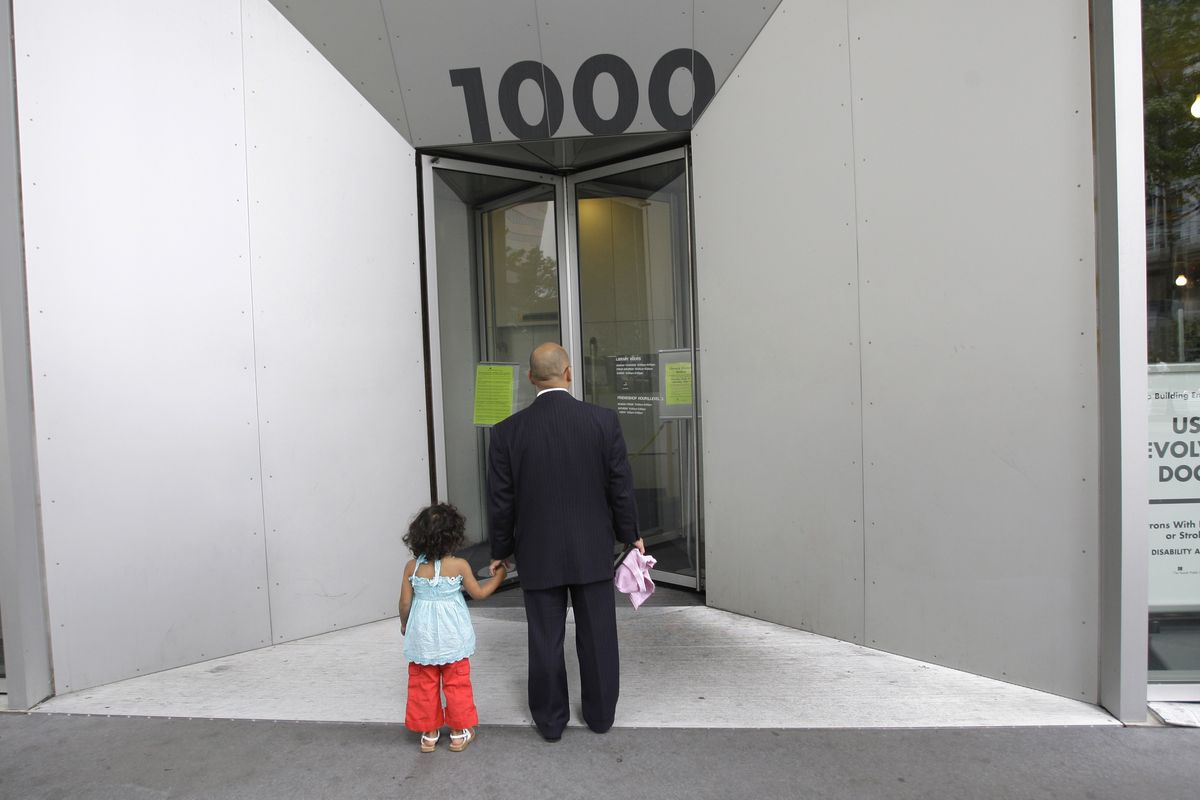 Serafin Aquino holds hands with daughter Isabella, 3, after they arrived at the main downtown branch of the Seattle Public Library on Tuesday, only to find a sign saying it was closed all week. Associated Press photos (Associated Press photos / The Spokesman-Review)