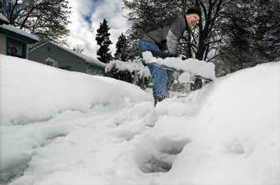 
Mark Russell clears a sidewalk for an elderly woman on West Chelan on Monday. 
 (Christopher Anderson / The Spokesman-Review)