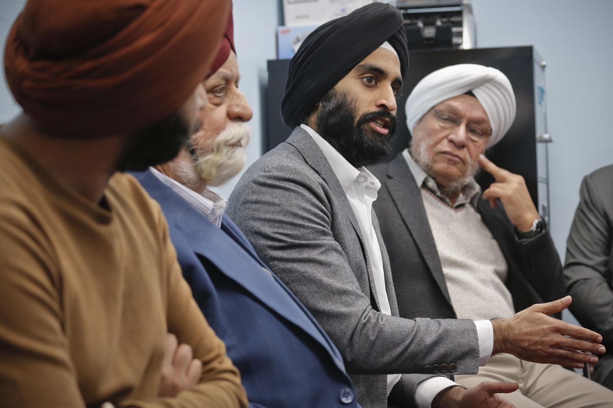 In this April 9, 2017, photo, Gurwin Ahuja, center, a 27-year-old political operative who helped organize a new awareness campaign to stop attacks against Sikhs, meets with Sikh leaders at the Guru Nanak Darbar house of worship, in Hicksville, N.Y. (Bebeto Matthews / Associated Press)